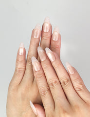 Hand wearing Naillover Crystal Whisper Singapore press on nails, showcasing soft nude gradient with subtle crystals and pearls