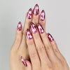 Model wearing Cupid's Curve handmade Singapore press on nails with magenta base, heart patterns, and rhinestone details