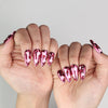 Romantic hand pose with Cupid's Curve handmade Singapore press on nails featuring magenta color and rhinestones