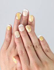 Close-up of hand wearing Daisy Glow Singapore press on nails with pastel pink base and small white daisy designs.
