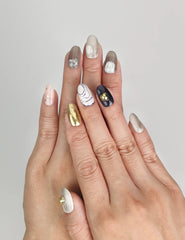 Model wearing Naillover Eclipse Core handmade Singapore press on nails with marbled neutral tones and gold accents.