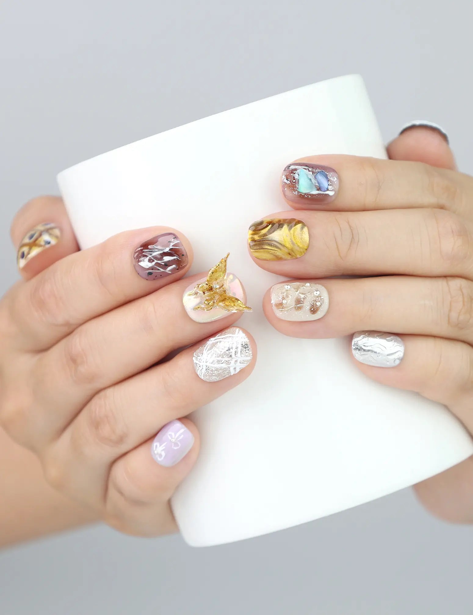 Ethereal Shimmer handmade press on nails worn while holding a cup—showcasing lilac shimmer and plaid artistry.