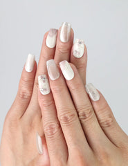 Close-up of hand wearing Flora Sheen press on nails by Naillover, showcasing pink and white floral gradient with a minimalist, 3D finish.