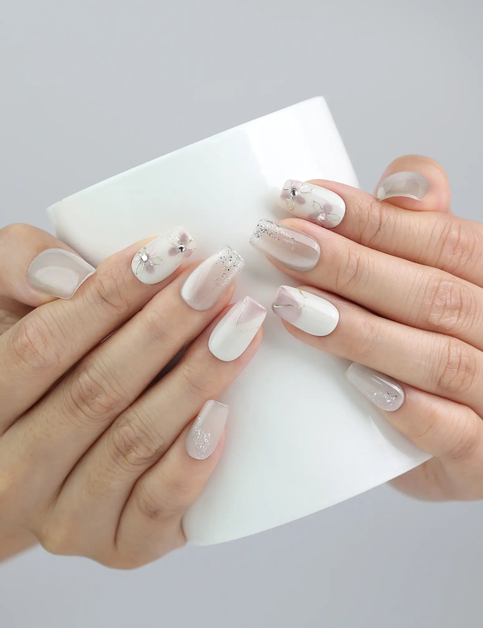 Hand holding a cup while wearing Flora Sheen Singapore press on nails, blending soft elegance with casual style.