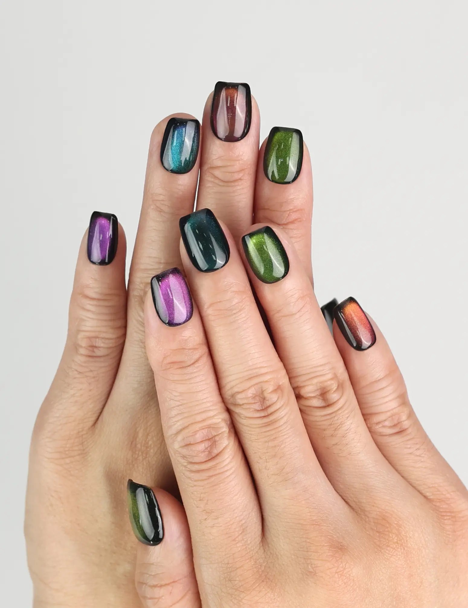 Hand wearing Galaxy Velvet black cat eye handmade press on nails from Singapore by Naillover, shimmering emerald highlights