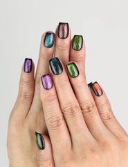 Hand wearing Galaxy Velvet black cat eye handmade press on nails from Singapore by Naillover, shimmering emerald highlights
