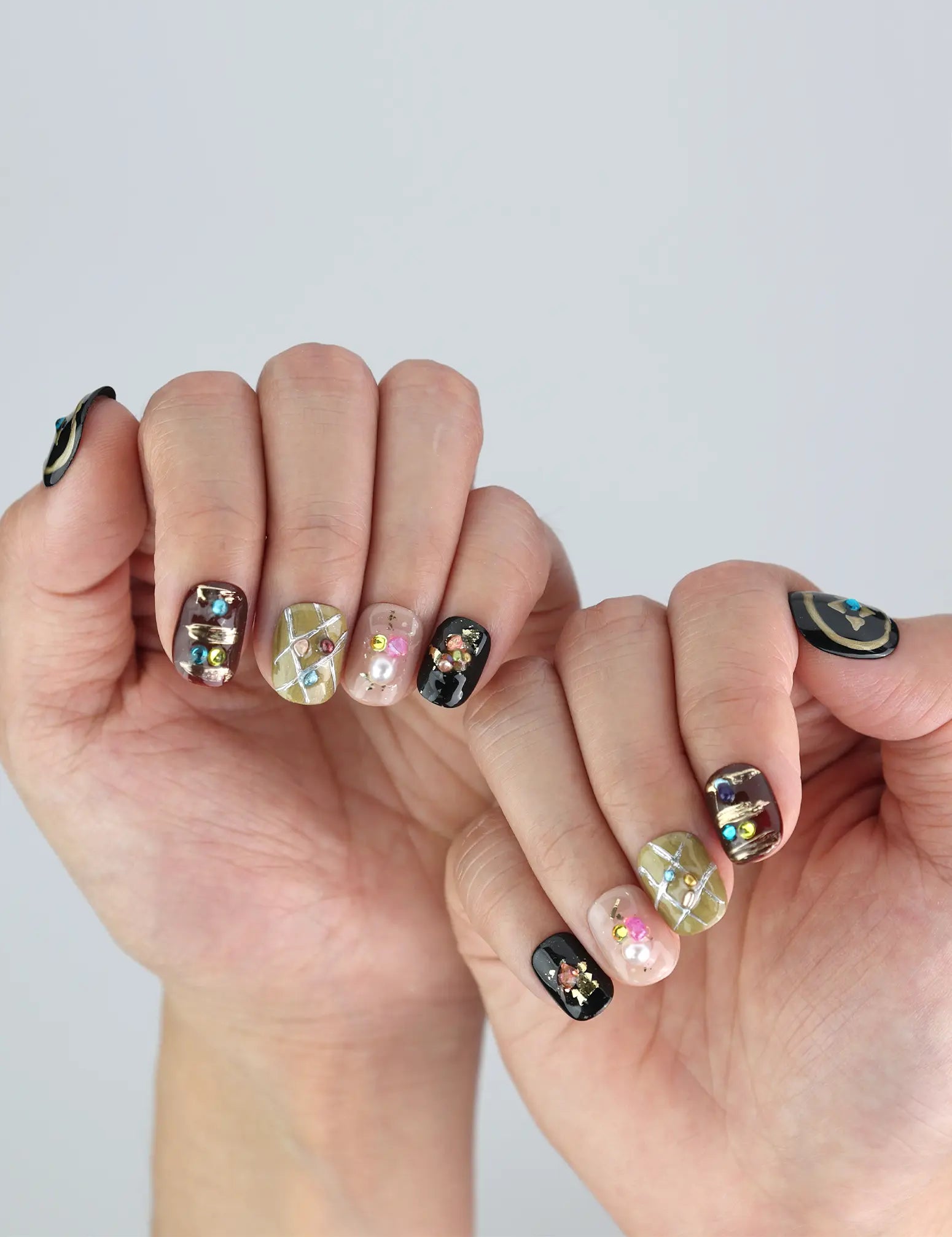 Naillover Gem Enchant nails on hand—sparkling black press on nails with Y2K-inspired 3D charm and stylish short length.