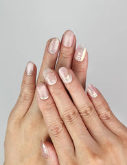 Model wearing Naillover Glimmer Blossom handmade Singapore press on nails with pink shimmer, gold leaf, and rhinestone accents.