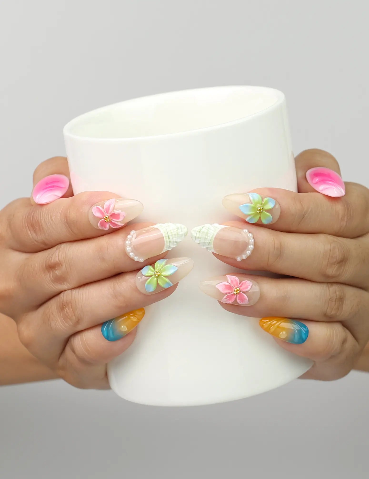 Model holding a cup while wearing Naillover Gradient Fantasy handmade press on nails with 3D floral and glitter details.