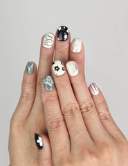 Model wearing Naillover Inky Blossoms handmade press on nails Singapore with bold black, white, and green floral art.