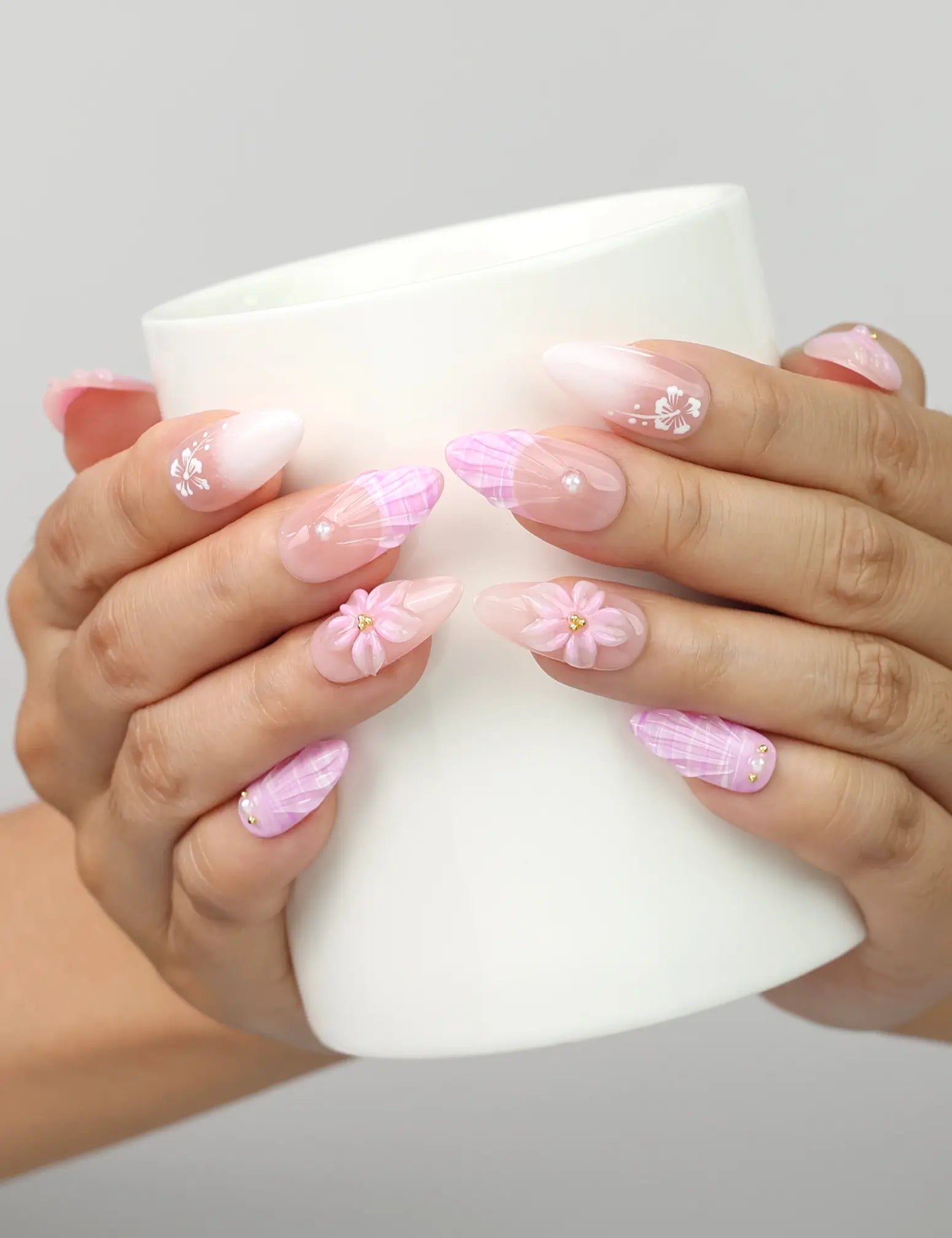Model holding a cup while wearing Naillover Lavender Bloom press on nails Singapore with floral patterns