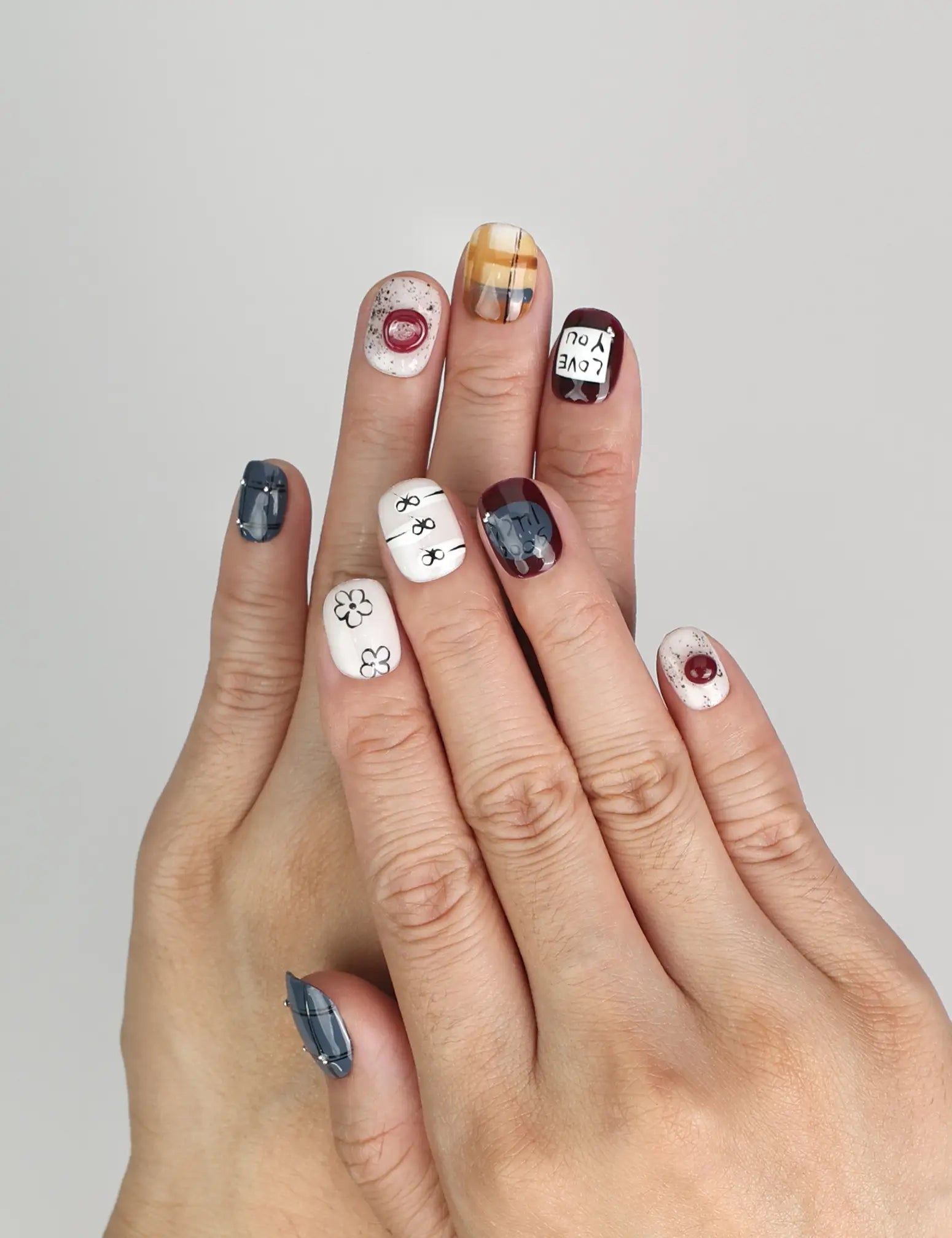 Model wearing Naillover Love Notes handmade Singapore press on nails with dark and light color contrast and romantic lettering.