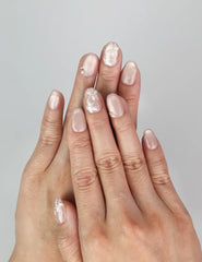 Model wearing Naillover Lucid Petals handmade Singapore press on nails in pink with gold floral and pearl accents.
