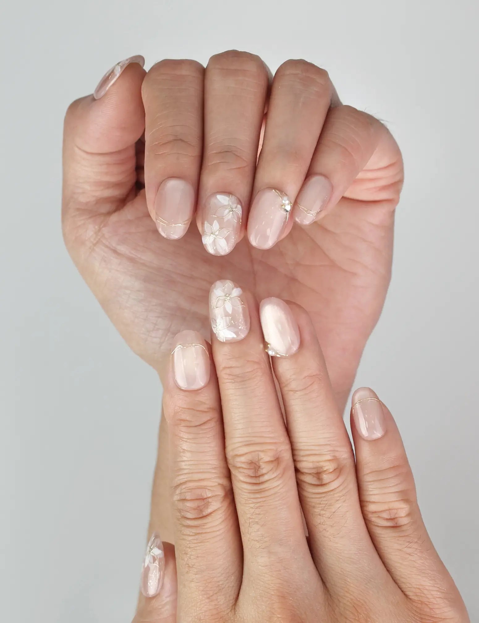 Close-up of Naillover Lucid Petals Singapore press on nails featuring delicate gold floral motifs and pearls.