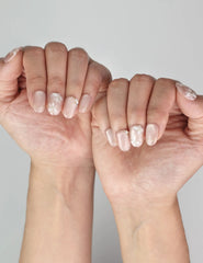 Naillover Lucid Petals handmade press on nails in soft pink with elegant pearl and floral details on model’s hand.