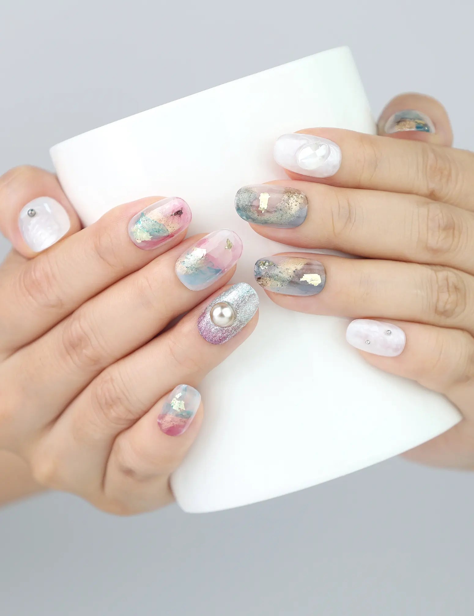 Holding a mug with Naillover Mermaid Sparkle nails, highlighting the dreamy jelly finish and gold detailing.