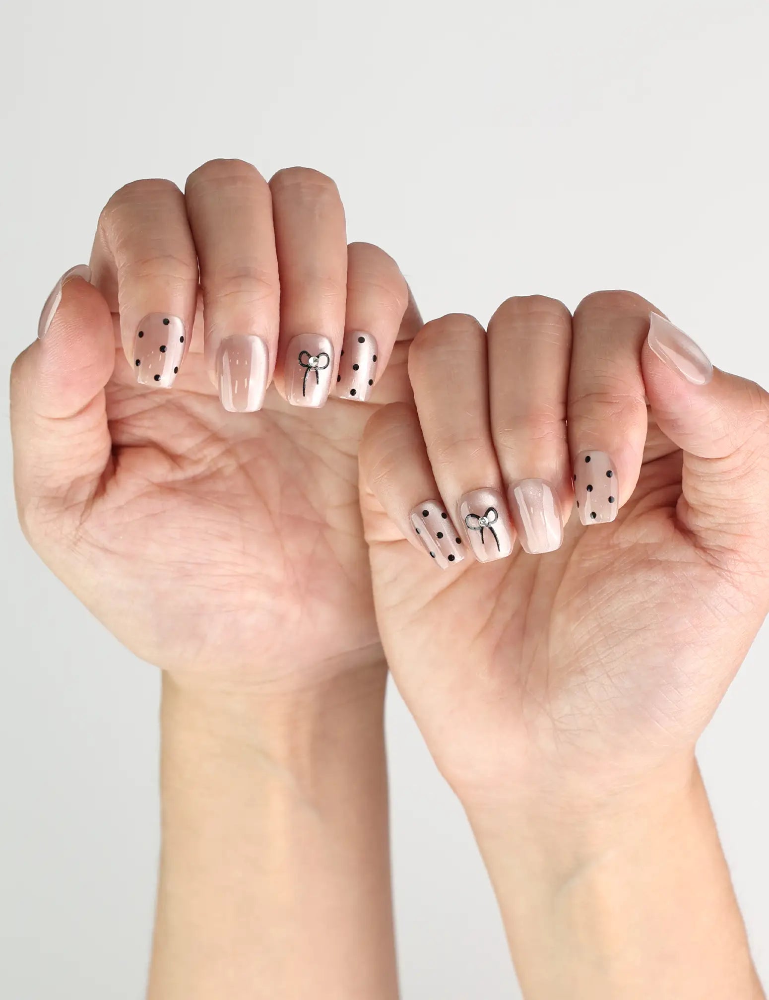 Naillover Mocha Dot cute nails design in taupe with white polka dots and bows, worn for a casual chic look