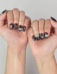 Close-up of hand wearing Naillover Mystic Maroon press on nails Singapore, showing glossy burgundy with striking blue and gold details