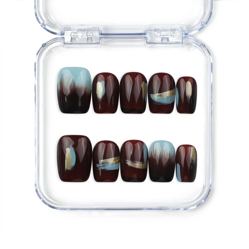 Close-up of Naillover Mystic Maroon handmade press on nails SG, showing burgundy base with blue and gold details, trendy and classic nail design