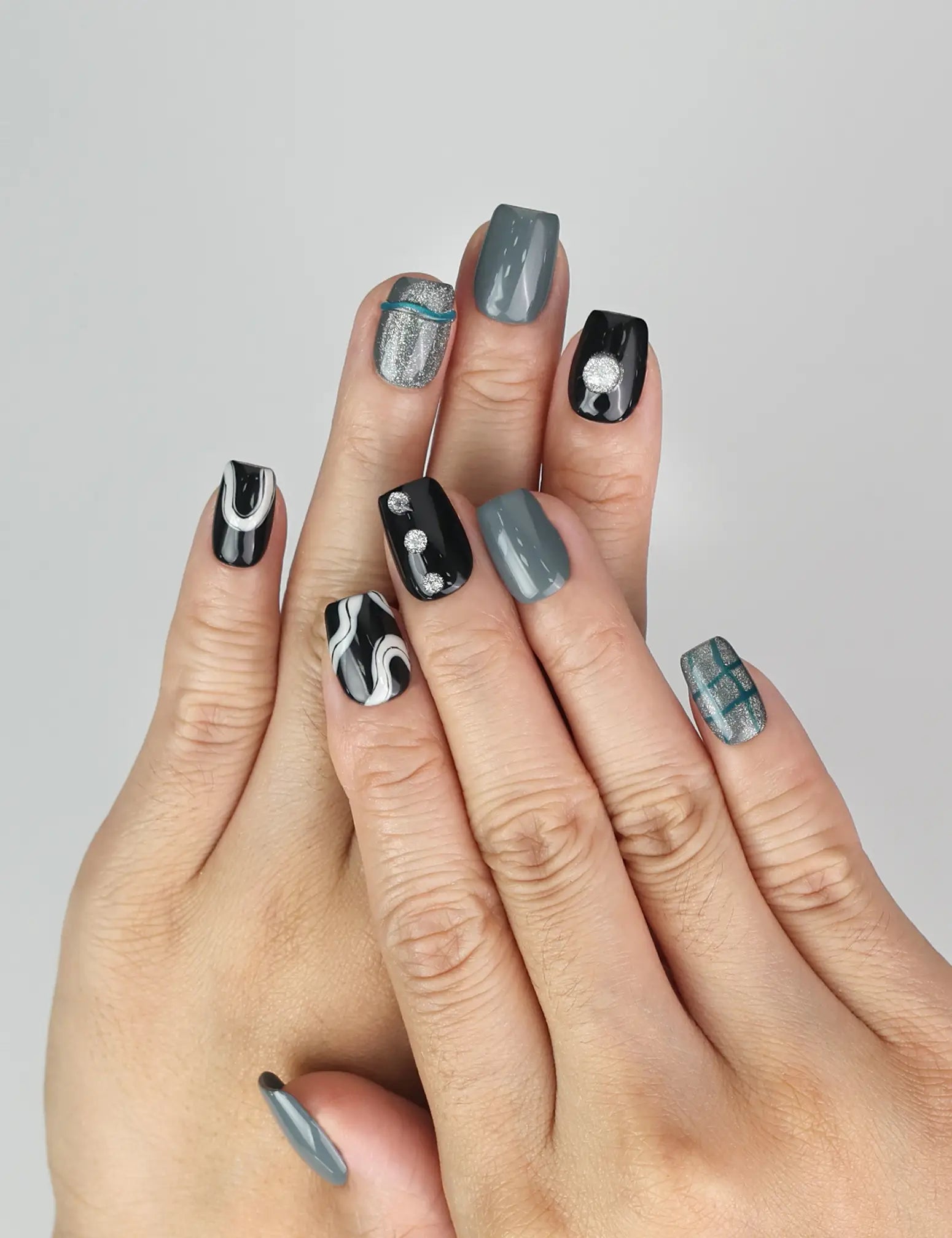 Model wearing Naillover Mystic Swirl handmade Singapore press on nails with black, grey, and marble white design.