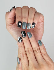 Close-up of Naillover Mystic Swirl classic handmade press on nails featuring silver glitter and green accents.