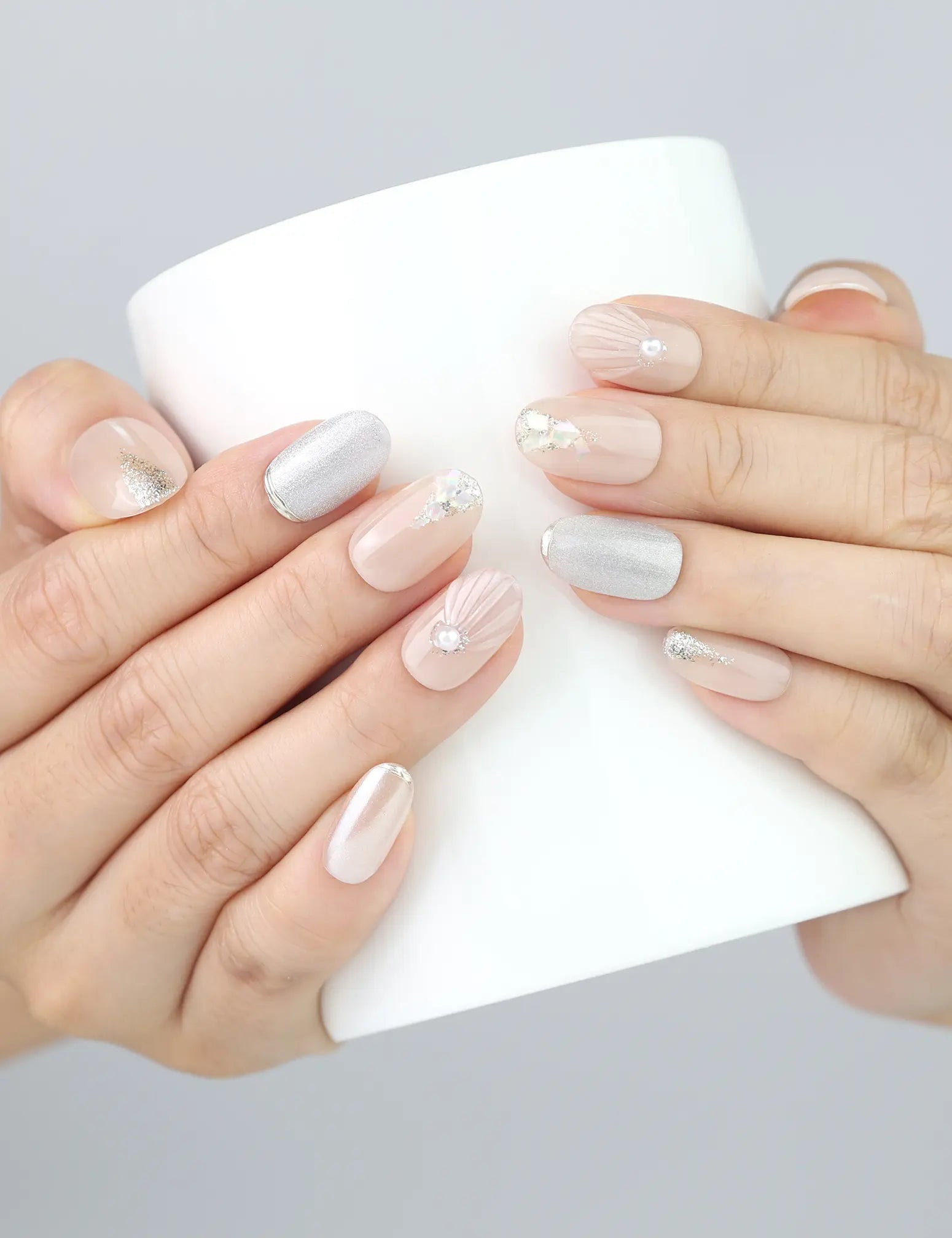 Wearing Naillover Nude Gleam nails while holding a cup—minimal and classy.