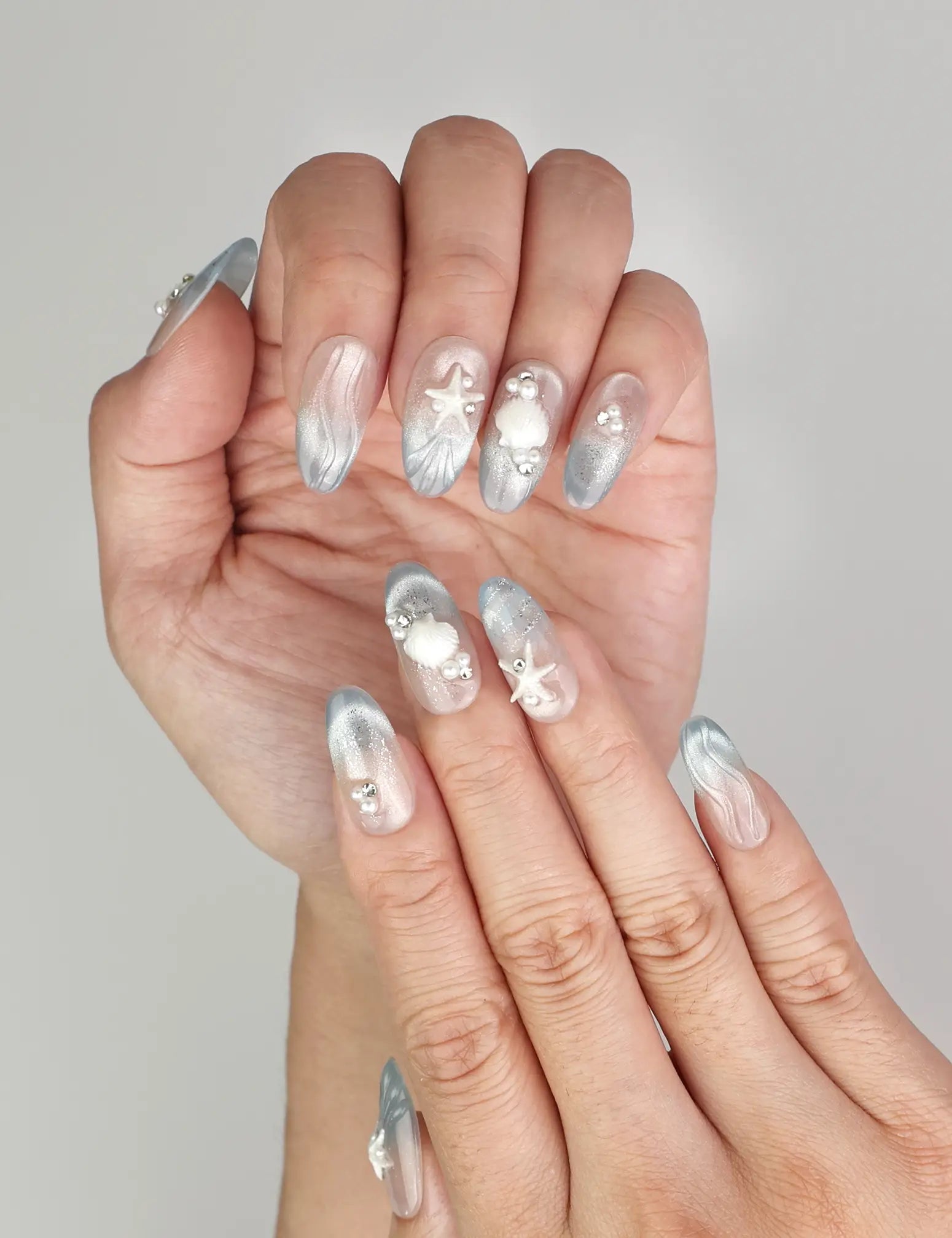 Close-up of Naillover handmade Ocean Whisper press on nails featuring pearl accents and trendy coastal design