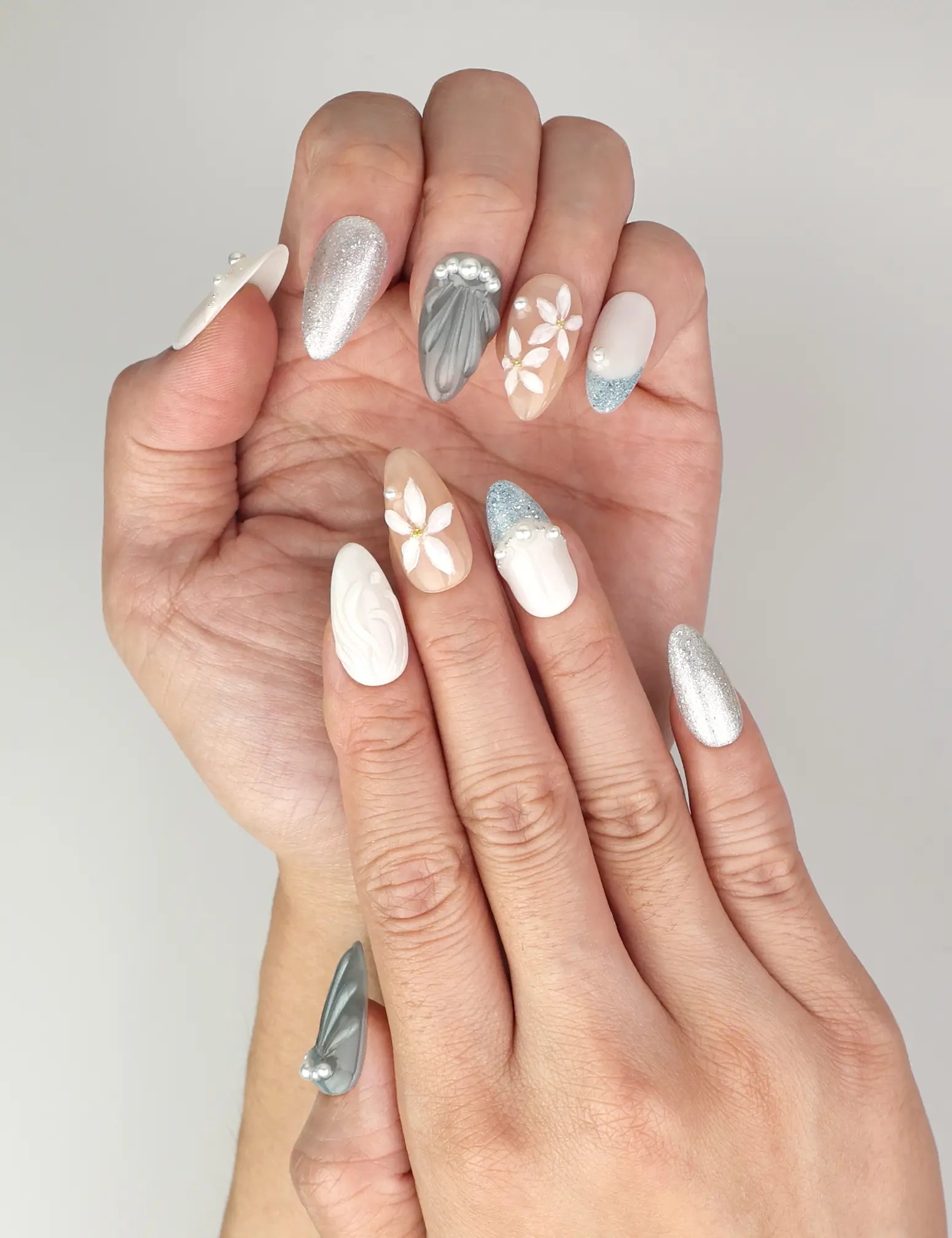 Elegant Naillover Oceanic Floral Breeze Singapore press on nails worn on hand with delicate flowers, pearls, and subtle glitter details.