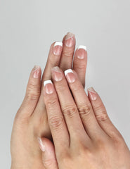 Model wearing Naillover Opal Scheme handmade Singapore press on nails in soft pink and white with silver line accents.