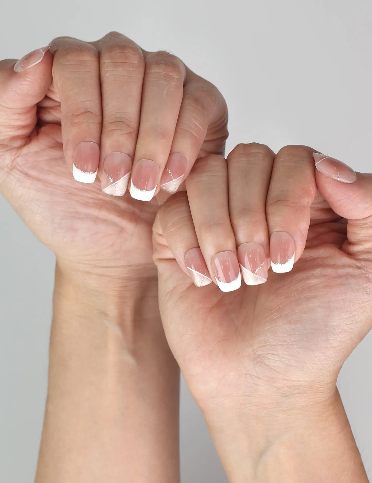 Naillover Opal Scheme classic handmade press on nails in pink and white tones with elegant silver accents on model’s hand.