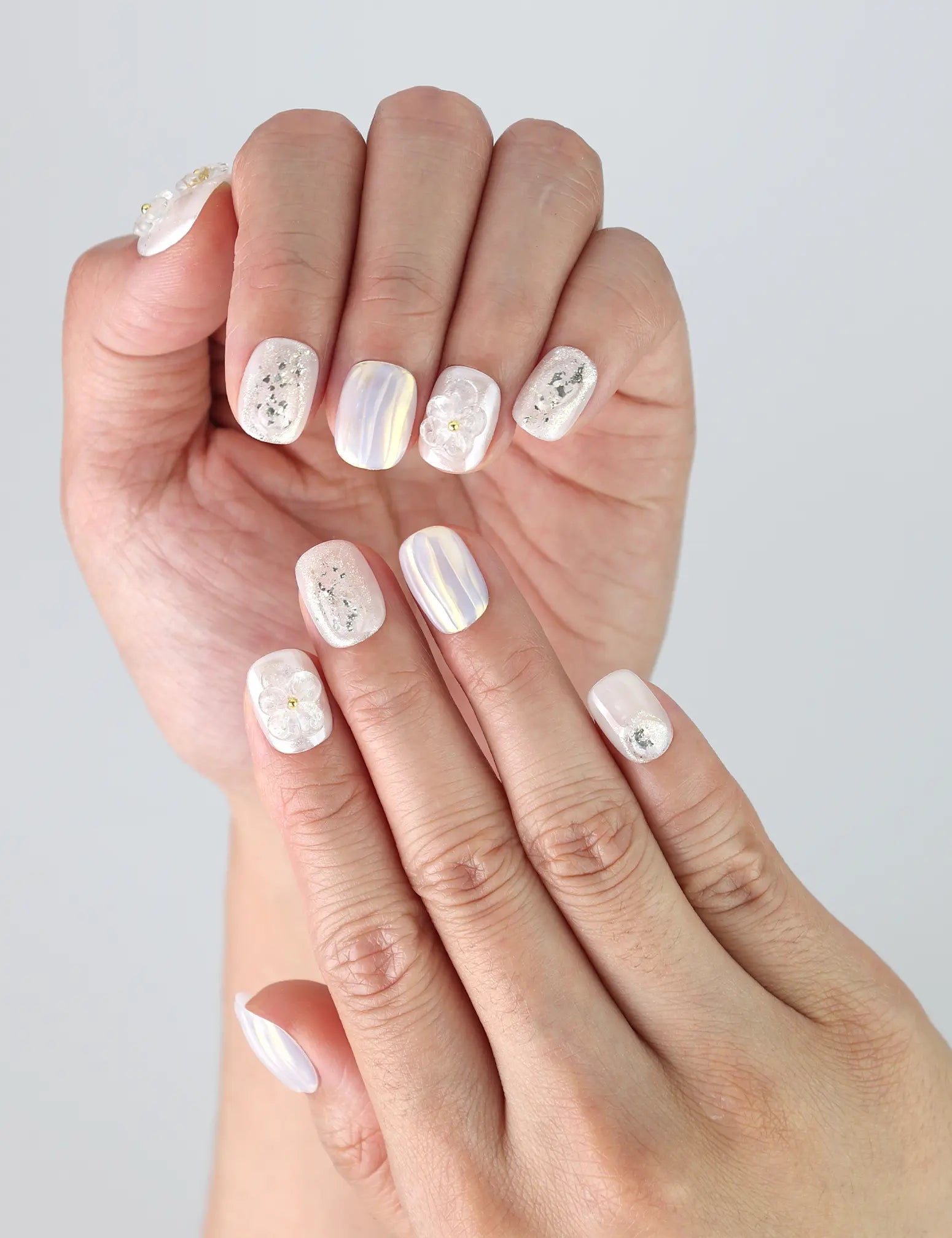 Side view of fingers with Pearl Haze Singapore press on nails showing raised floral detail and natural glossy finish.