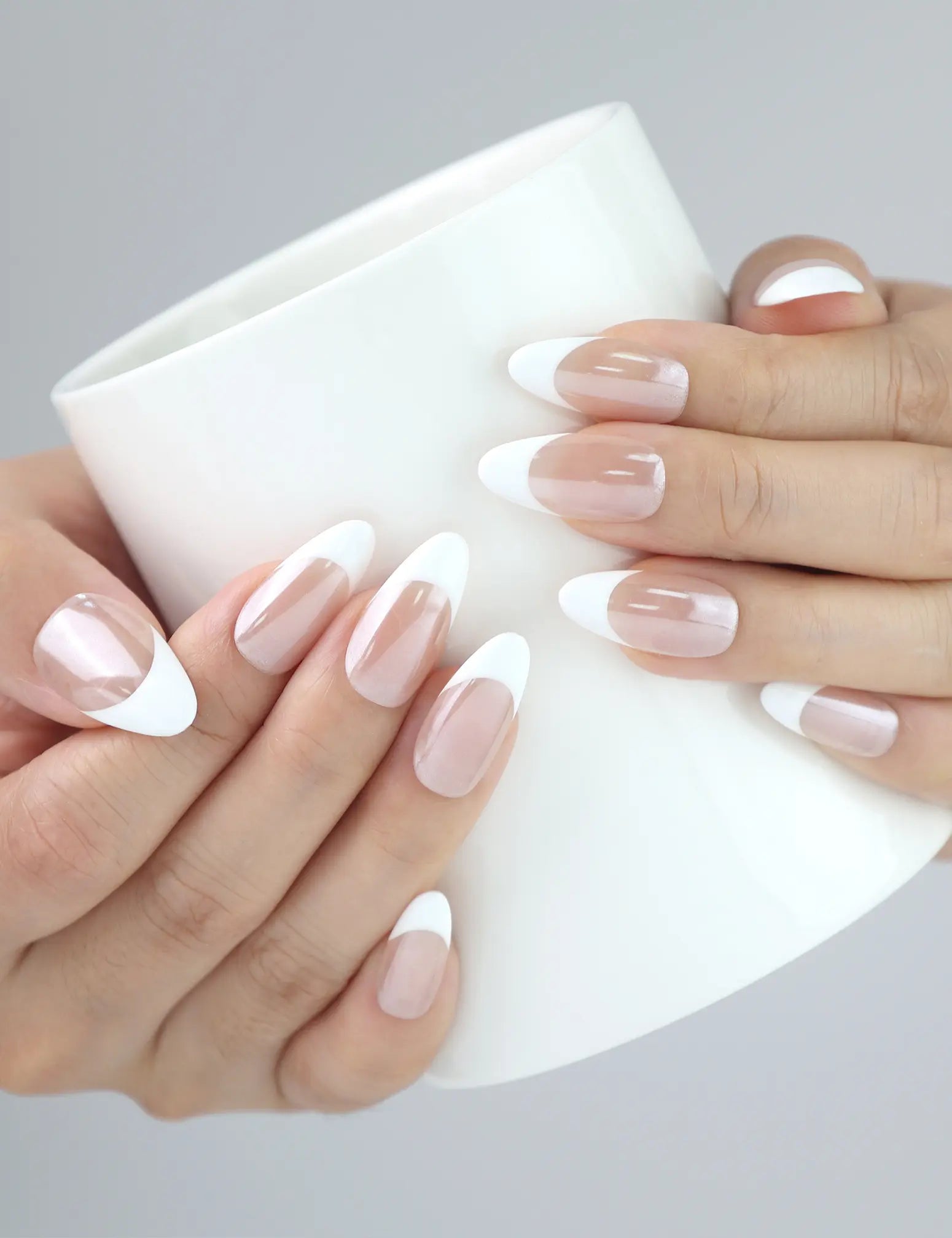Hand holding coffee cup with Pearly Shine nails — Naillover handmade press ons in pearly white, perfect for daily elegance.
