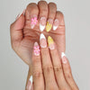 Close-up of Naillover Petal Dream 3D summer nails showing pink gradient base and golden embellishments.