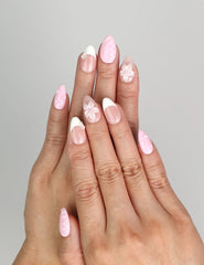 Model wearing Naillover Petal Grace handmade press on nails Singapore with pink gradient and floral motifs.