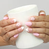 Model holding a cup while wearing Naillover Petal Grace handmade press on nails with floral accents.