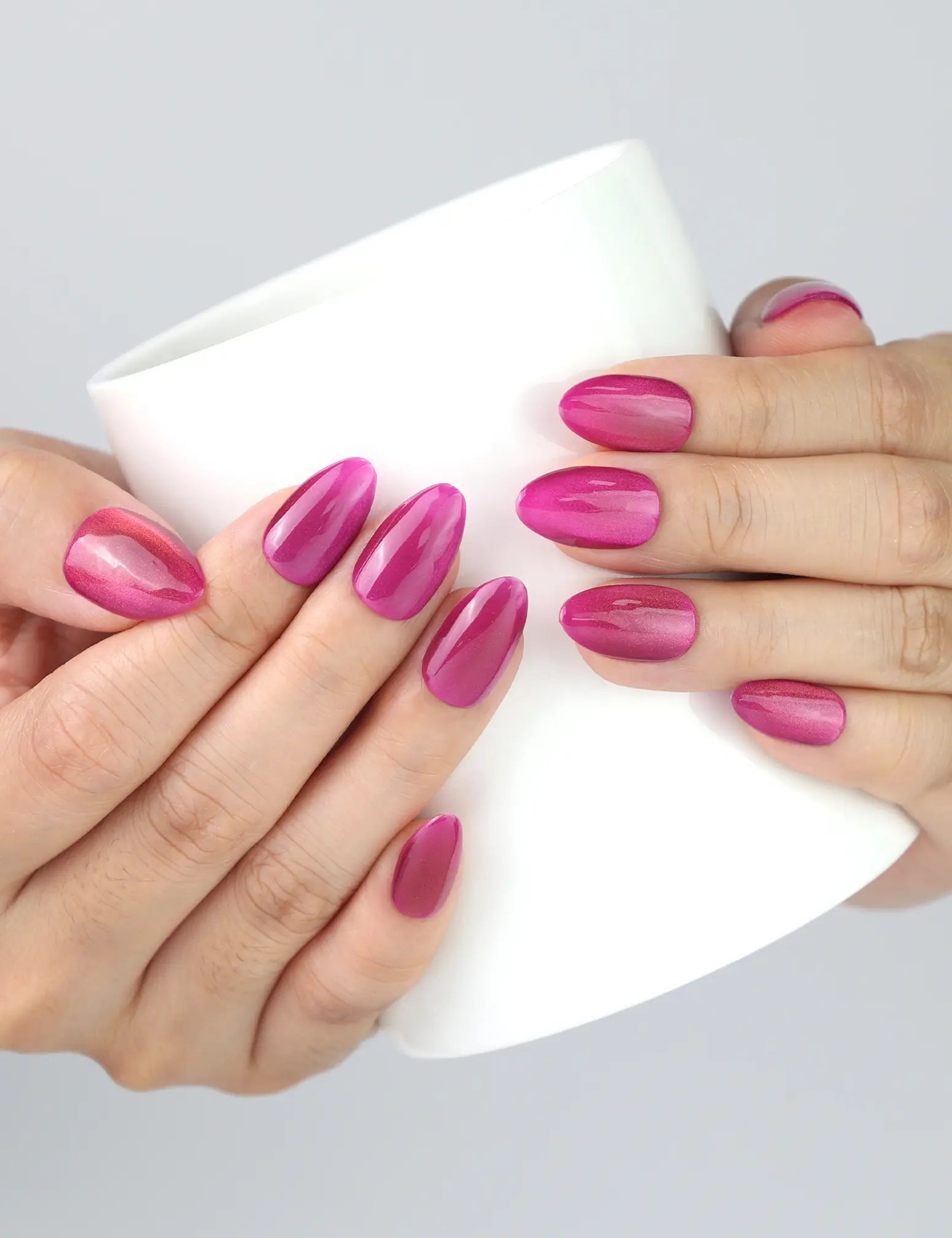 Holding a cup while wearing Purple Pulse handmade purple cat eye press on nails by Naillover Singapore.