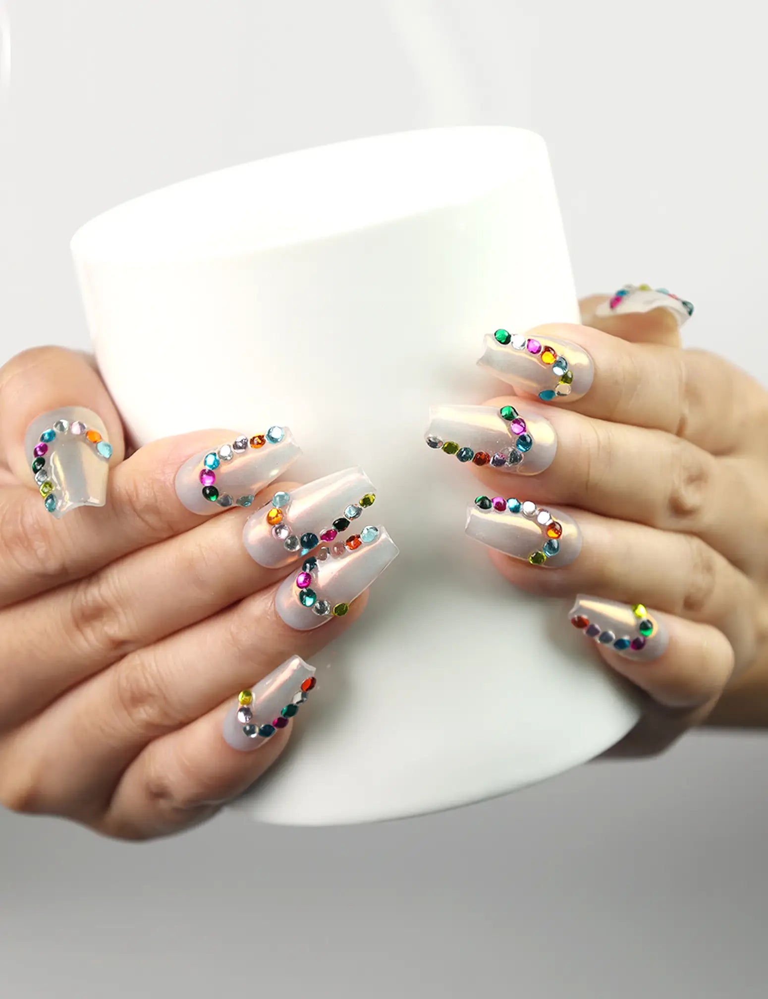 Rainbow Arc Singapore press on nails by Naillover in colorful rainbow style, shown holding a coffee cup