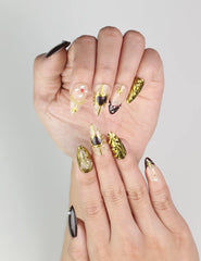 Close-up of Regal Radiance Singapore press on nails by Naillover showcasing intricate gold designs and pearls on burgundy base
