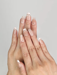 Model wearing Naillover Serene Loops handmade Singapore press on nails with nude base and pearl accents.