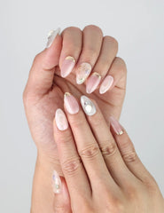 Close-up of Shimmer Floral press on nails on fingers, highlighting delicate shimmer and hand-painted flower art.
