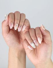 Angled view of hands wearing Naillover’s Shimmer Floral nails, showcasing soft sparkle and feminine detail.