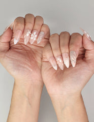 Close-up of Naillover Shimmering Pearl And Floral Elegance handmade press on nails worn on hand with shimmer and delicate floral art.