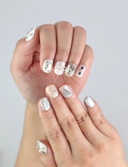 Close-up of Naillover’s handmade Silver Bow nails—short square shape in white with metallic silver details, part of the Singapore press on nails line.