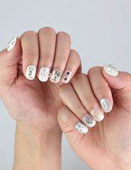 Naillover Silver Bow press on nails styled on hand—featuring clean white base and elegant silver designs for timeless simplicity.
