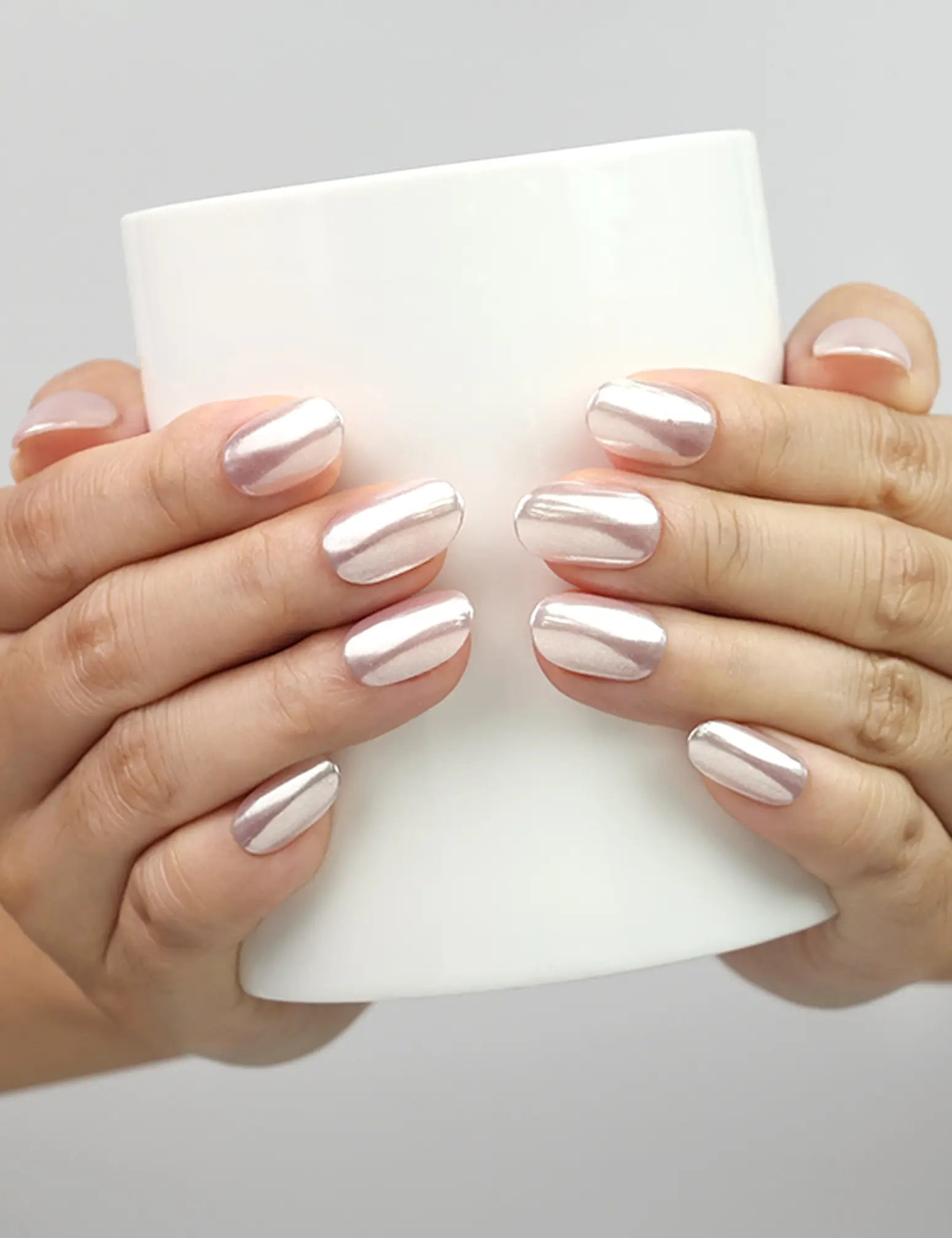 Model holding cup with Naillover Soft Sparkle trendy press on nails SG, glowing finish