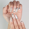 Close-up of Subtle Knots Singapore press on nails by Naillover showing metallic details on a beige background