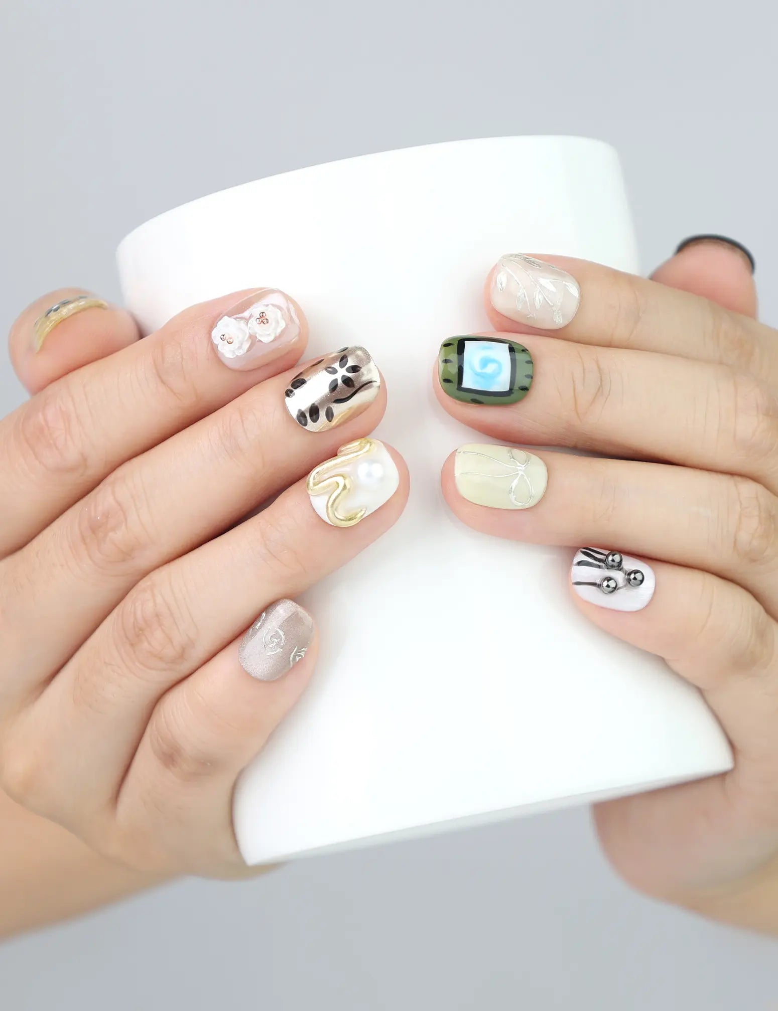 Naillover Vintage Bloom nails holding a latte mug—highlighting the soft floral 3D details and gentle pastel shades.