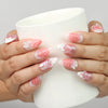 Model holding a cup while wearing Naillover Whisper of Wisteria handmade press on nails Singapore with butterfly and floral embellishments.