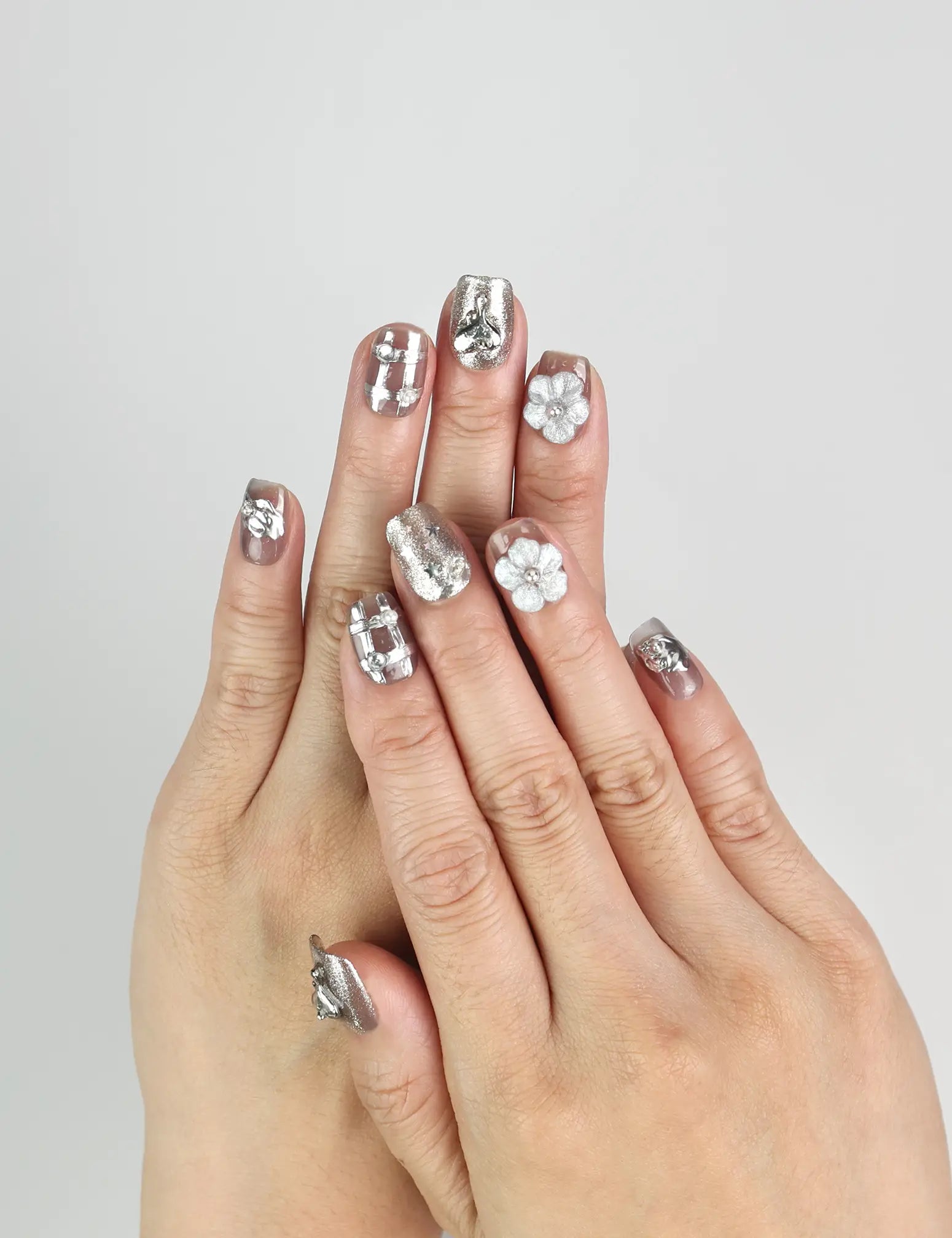 Hand wearing Nightfall handmade Singapore press on nails in metallic silver with rhinestones, evening-ready style by naillover.
