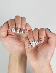 Model showcasing Nightfall handmade metallic silver press on nails with rhinestones, trendy look by naillover.
